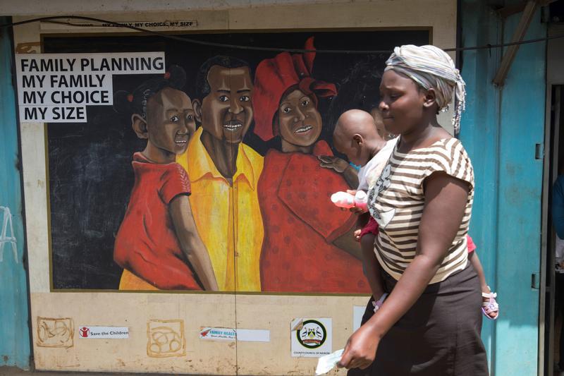 A woman walks past a mural on a Family Health Options clinic in the Kibera slums in Nairobi, Kenya, May 16, 2017. © 2017 Reuters