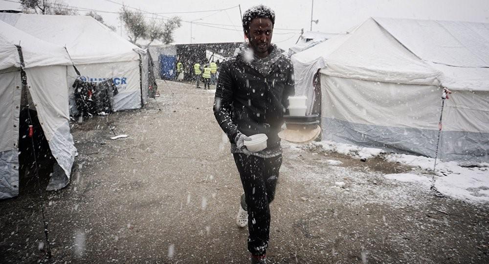 Un migrant marche entre des tentes dans le camp de réfugiés de Moria sur l'île grecque de Lesbos, lors d'une chute de neige, le 9 janvier 2017.