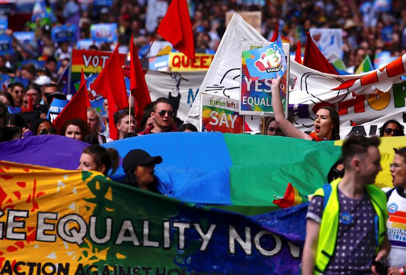 Marchers hold signs and banners as they participate in a marriage equality march in central Sydney, Australia on October 21, 2017.