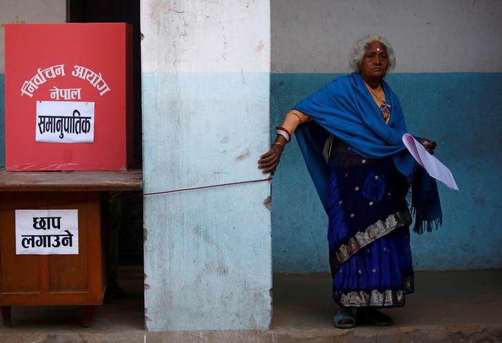 A woman walks to cast her vote during elections in Thimi, Nepal, December 7, 2017.