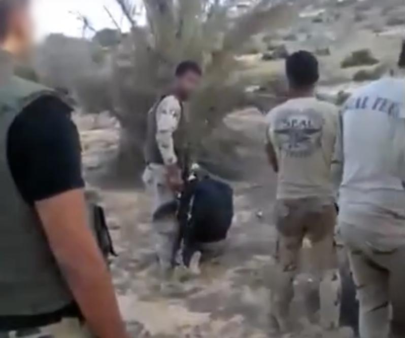 عنصر من ميليشيا مسنودة من الجيش يستعد لإعدام محتجز ثان .