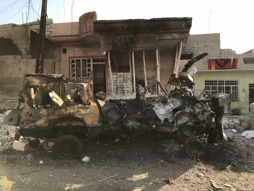 A car destroyed and home damaged by an ISIS car bomb targeting Iraqi Security Forces on January 1, 2017 that wounded at least one civilian.