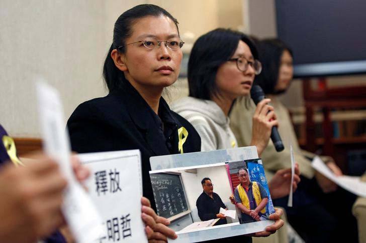 Li Ching-yu (C), a wife of Taiwanese human rights activist Li Ming-che, detained in China, attends a news conference in Taipei, Taiwan March 31, 2017.REUTERS/Tyrone Siu