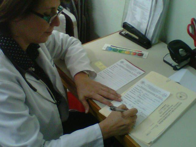 Dr. Eva Duarte writing prescriptions for her patients