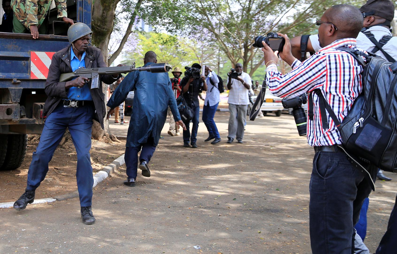 Un membre des forces de l’ordre antiémeutes s’apprête à tirer une grenade lacrymogène alors que des journalistes couvrent une manifestation contre la corruption dans la capitale du Kenya, Nairobi, le 3 novembre 2016. 