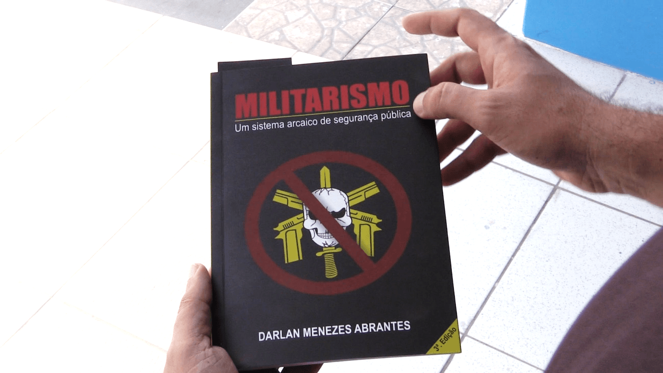 Former military police officer Abrantes holds his book.