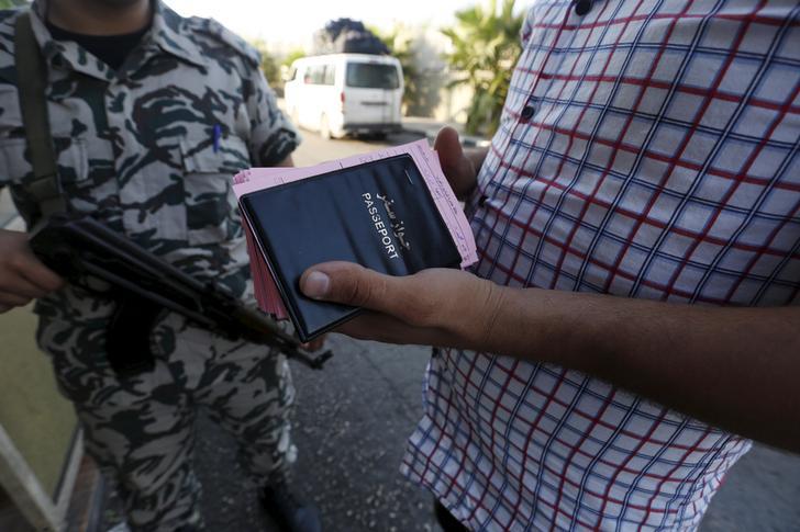 عنصر من الأمن العام يقف قرب سائق حافلة يحمل جوازات وبطاقات مغادرة لسوريين وافدين على لبنان.