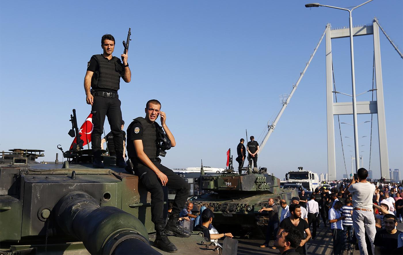 Policemen stand atop military armored vehicles after troops involved in the coup surrendered on the Bosphorus Bridge in Istanbul, July 16, 2016. 