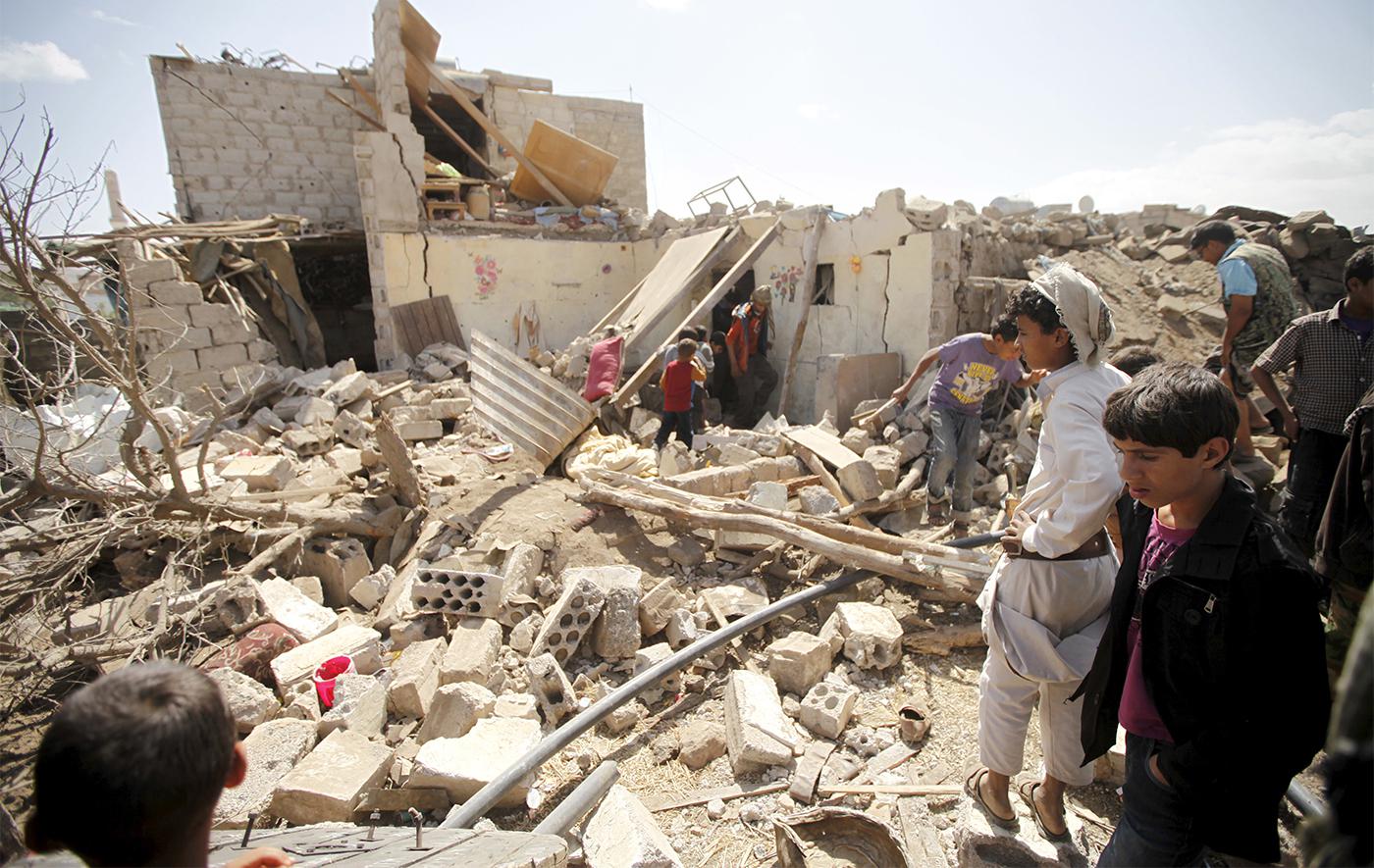 أناس يتفقدون الأضرار في منزل بعد تدميره في غارة جوية شنه التحالف بقيادة السعودية في العاصمة اليمنية صنعاء، 25 فبراير/شباط 2016.