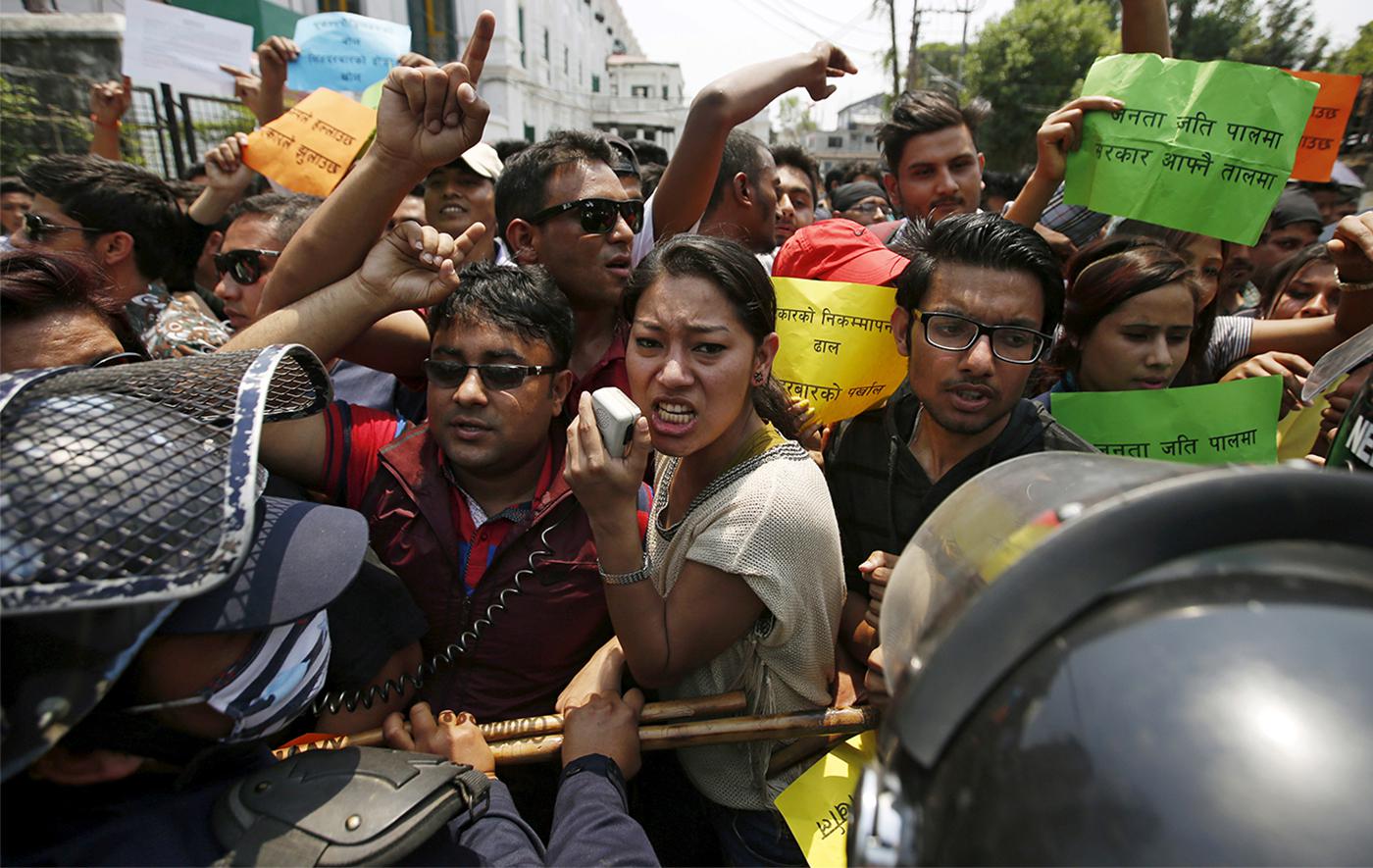Nepalese police try to stop protesters marching towards the prime minister's office and other ministries, during a demonstration against delays on reconstruction and relief during the first anniversary of the 2015 earthquakes in Kathmandu, April 24, 2016.