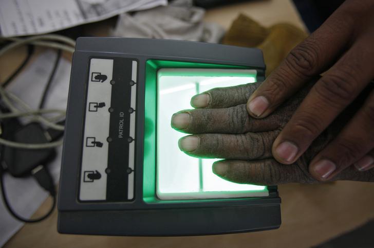 201801asia_india_dna A villager goes through the process of a fingerprint scanner for the Unique Identification (UID) database system at an enrolment center at Merta district in the desert Indian state of Rajasthan on February 22, 2013.