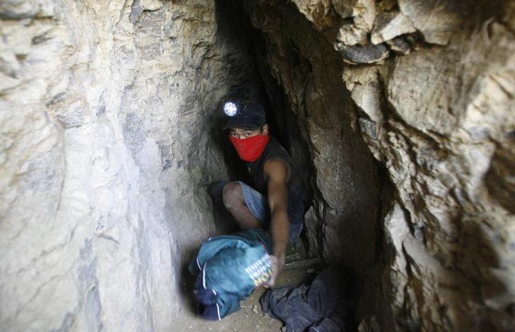 201801asia_indonesia_goldmine An illegal miner leaves a cave after mining for gold in the mountain of Tumpang Pitu in Banyuwangi, East Java November 21, 2009.