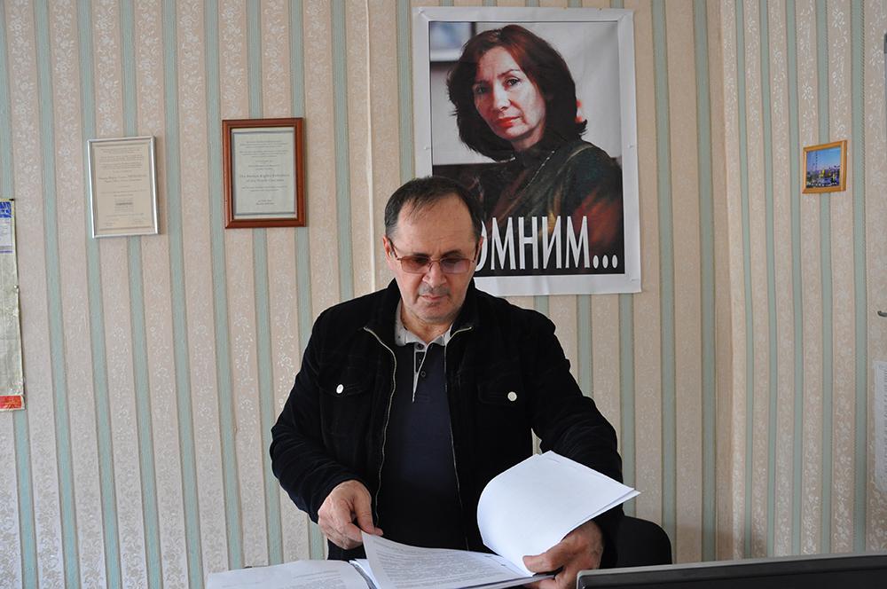 Le directeur du bureau de Memorial en Tchétchénie, dans le sud de la Russie Oyub Titiyev, photographié en 2011 dans son bureau à Grozny. Un portrait de Natalia Estemirova, sa collègue assassinée en 2009, est visible derrière lui.