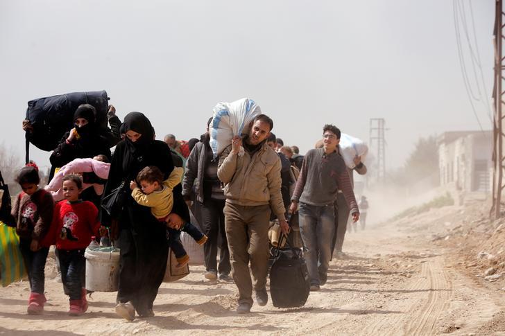 People walk with their belongings as they flee the rebel-held town of Hammouriyeh, in the village of Beit Sawa, eastern Ghouta, Syria March 15, 2018. REUTERS/Omar Sanadiki