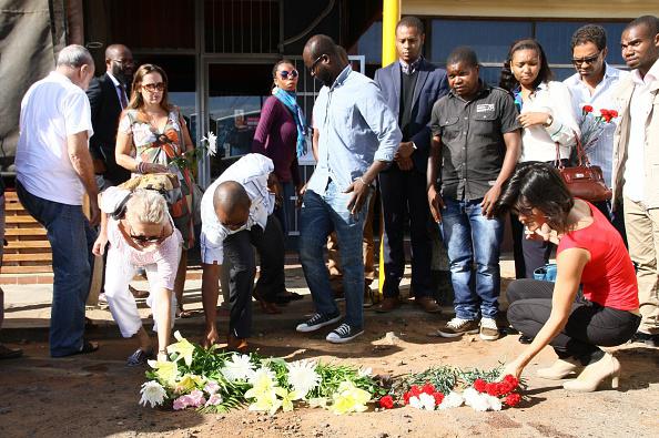 Grupo de pessoas colocam flores e prestam homenagem no local onde o especialista em Direito Constitucional Gilles Cistac foi assassinado em 3 de março de 2015, em Maputo, Moçambique.