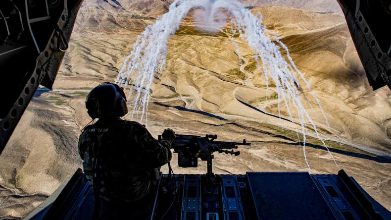 A US army crew chief flying onboard a Chinook helicopter observes a test of flares during a training flight in Afghanistan, March 14, 2018.