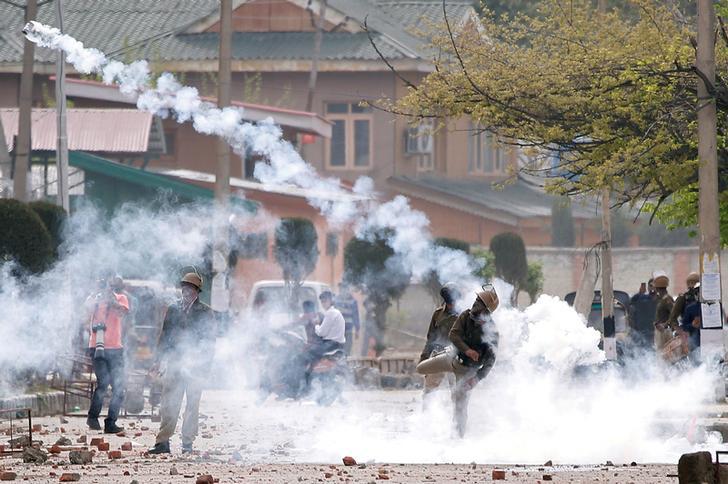 : Seorang polisi India melemparkan granat asap air mata ke arah pelajar saat aksi unjuk rasa terhadap pembunuhan baru-baru ini di Kashmir, 5 April 2018. 