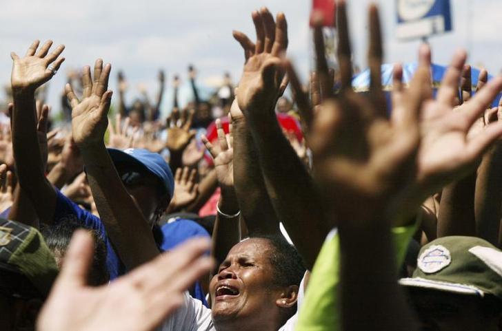 Warga Kristen Papua bernyanyi ketika demonstrasi di Jayapura, ibukota provinsi Papua, pada 5 Agustus 2008. Sekitar 1,000 orang Papua protes terhadap rencana pemerintah Indonesia memperkenalkan beberapa aturan Syariah Islam.