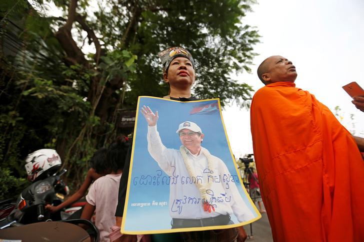 Supporters of Kem Sokha, former opposition leader and ex-president of the now-dissolved Cambodia National Rescue Party (CNRP), hold up a poster near the Appeal Court in Phnom Penh, Cambodia, March 27, 2018. 