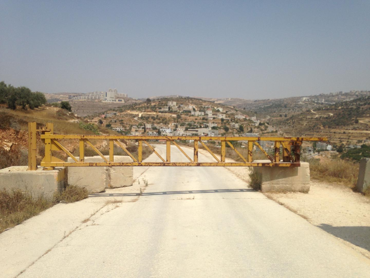 Un barrage routier érigé par une compagnie israélienne sur une route secondaire située à proximité de la colonie de Dolev, en Cisjordanie, empêche les habitants palestiniens du village d'Ein Qinya de continuer sur cette route afin de rejoindre le principa