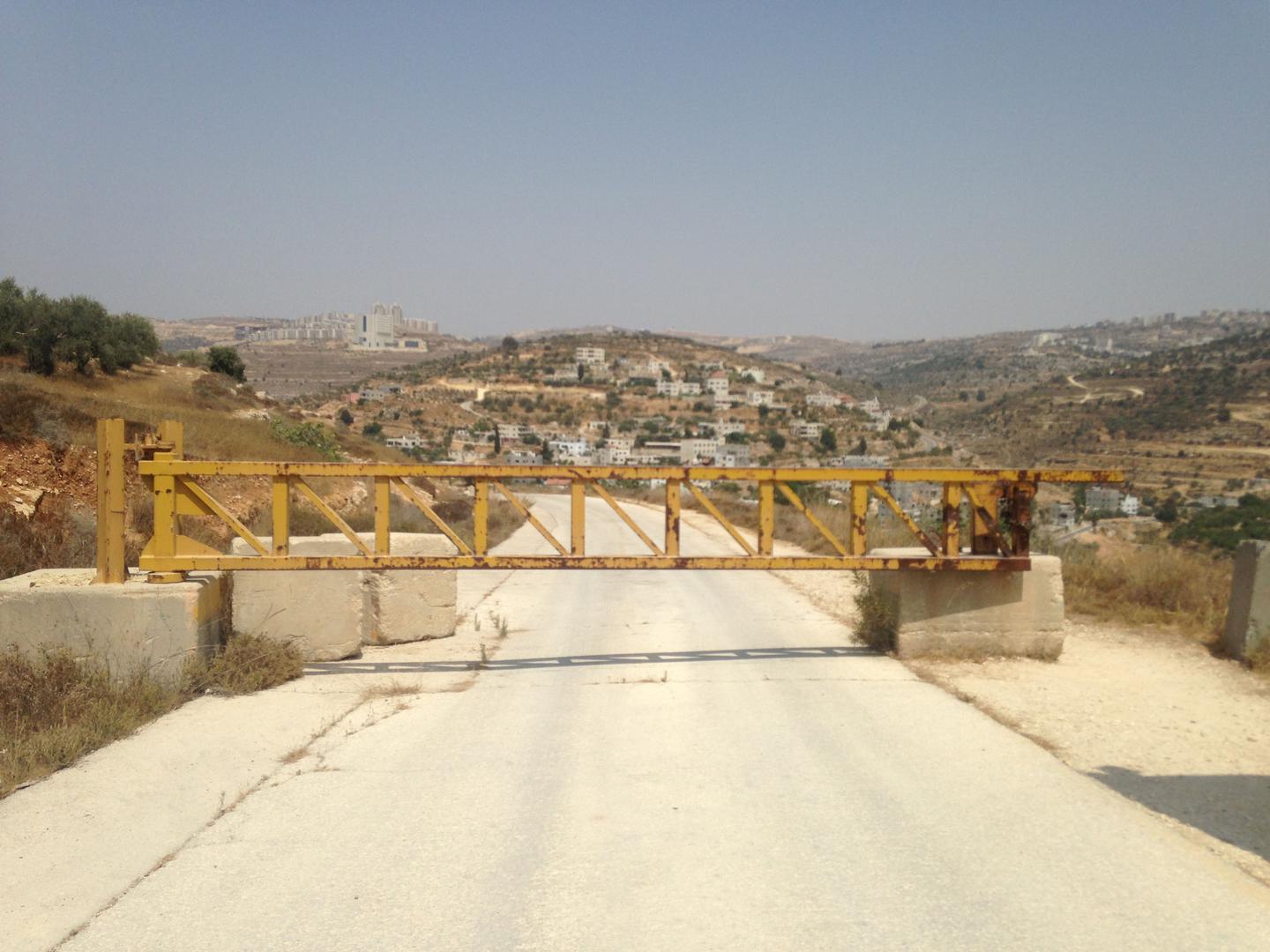 A road near the Israeli settlement of Dolev, where a gate blocks Palestinians from the nearby village of Ein Qinya from driving to the main road. Un camino cerca del asentamiento israelí de Dolev, donde una puerta bloquea el acceso a la carretera principa