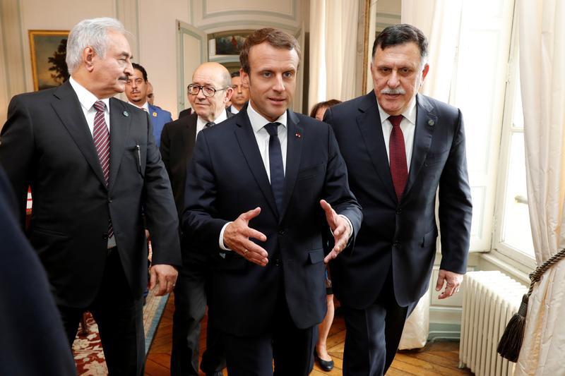 French President Emmanuel Macron walks with Libyan Prime Minister Fayez al-Sarraj and General Khalifa Haftar, commander in the Libyan National Army (LNA), before a meeting for talks over a political deal to help end Libya’s crisis in La Celle-Saint-Cloud 