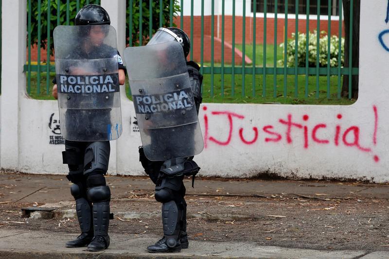 Riot police officers stand in front of a graffiti that reads "Justice" during a protest against Nicaragua's President Daniel Ortega's government in Managua, Nicaragua May 28, 2018. 