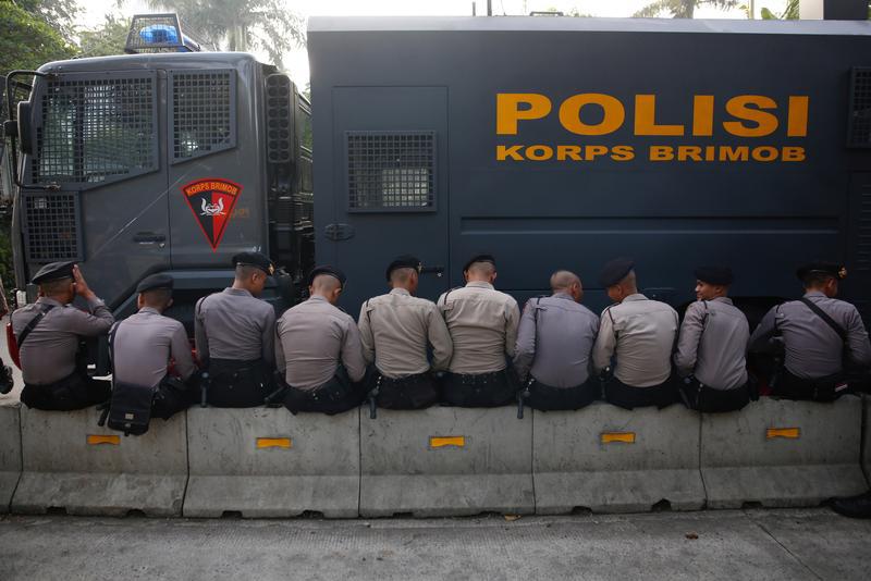 Petugas kepolisian duduk di depan sebuah gedung pengadilan di Jakarta, Indonesia, 9 Mei 2017. 