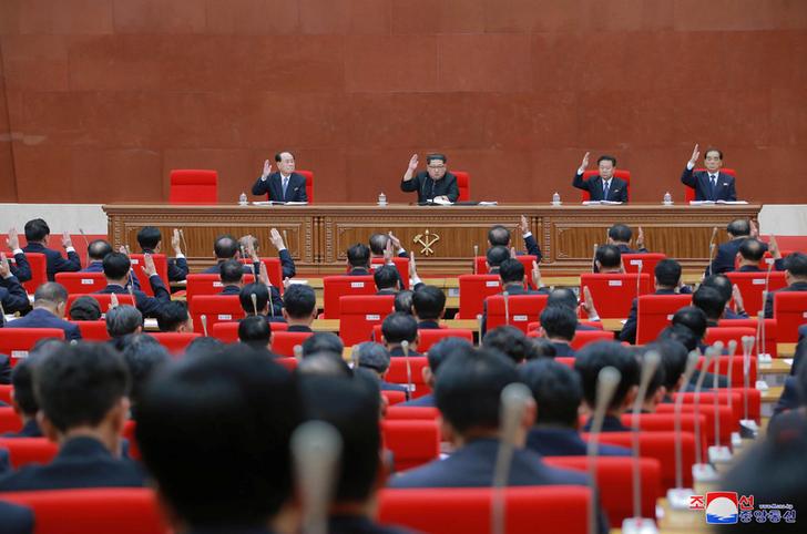 Le dirigeant nord-coréen Kim Jong-un (2ème à gauche) lève la main, lors d’une séance plénière du Comité central du Parti des travailleurs de Corée à Pyongyang, le 20 avril 2018. 