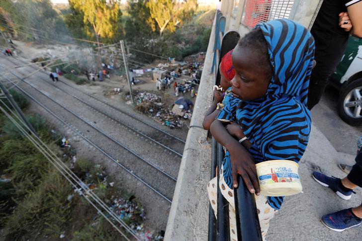 Une jeune migrante africaine photographiée le 28 juin 2017 sur un pont routier, sous lequel un camp de fortune a été érigé au bord d’une autoroute à la périphérie d'Alger. 