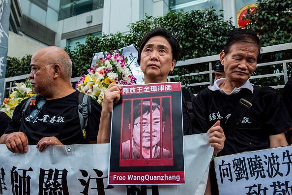 Caption: Hong Kong former lawmaker Emily Lau holds a sign of detained Chinese human rights lawyer Wang Quanzhang at a rally outside the Chinese Liaison Office in Hong Kong on April 5, 2018. © 2018 Getty Images