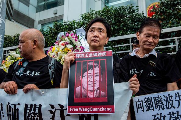 香港前立法会议员刘慧卿高举中国人权律师王全璋照片，在中联办前抗议，香港，2018年4月5日。