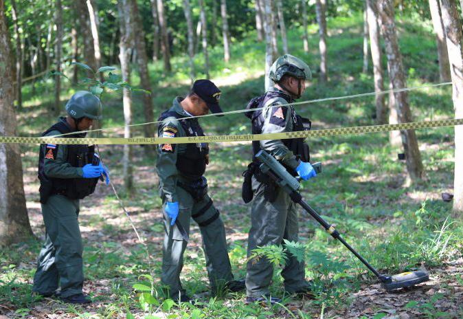 Thai security forces inspect a rubber plantation, where an ethnic Thai Buddist latex tapper lost his foot after stepping on a landmine laid by separatist insurgents in Yala province on July 2, 2018.