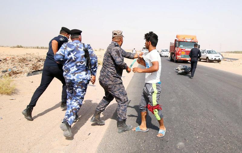 عنصر أمن عراق يمسك بمتظاهر قرب حقل البرجسية النفطي قرب البصرة، العراق، 17 يوليو/تموز 2018. © 2018 عصام السوداني/رويترز