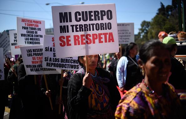 An indigenous woman holds a placard reading 'My Body My Territory Is to be Respected' as she demonstrates on International Women's Day in Guatemala City on March 8, 2018. 