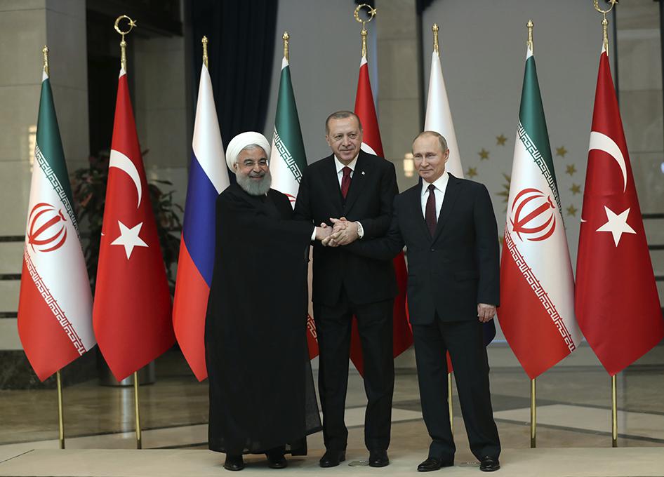 رؤساء إيران وروسيا وتركيا، حسن روحاني وفلاديمير بوتين ورجب طيب إردوغان، يشبكون أياديهم في صورة جماعية في أنقرة، تركيا، الأربعاء 4 أبريل/نيسان 2018.