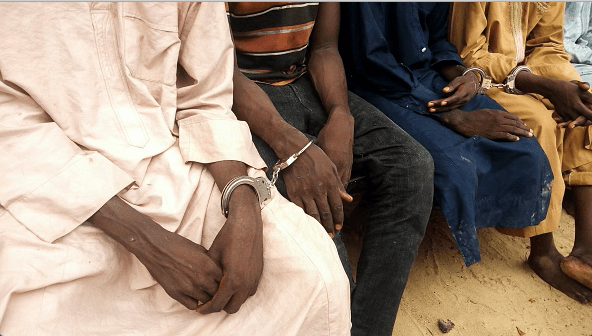 Police officers outline handcuffed suspected Boko Haram militants in Maiduguri, northest Nigeria, on July 18, 2018. 