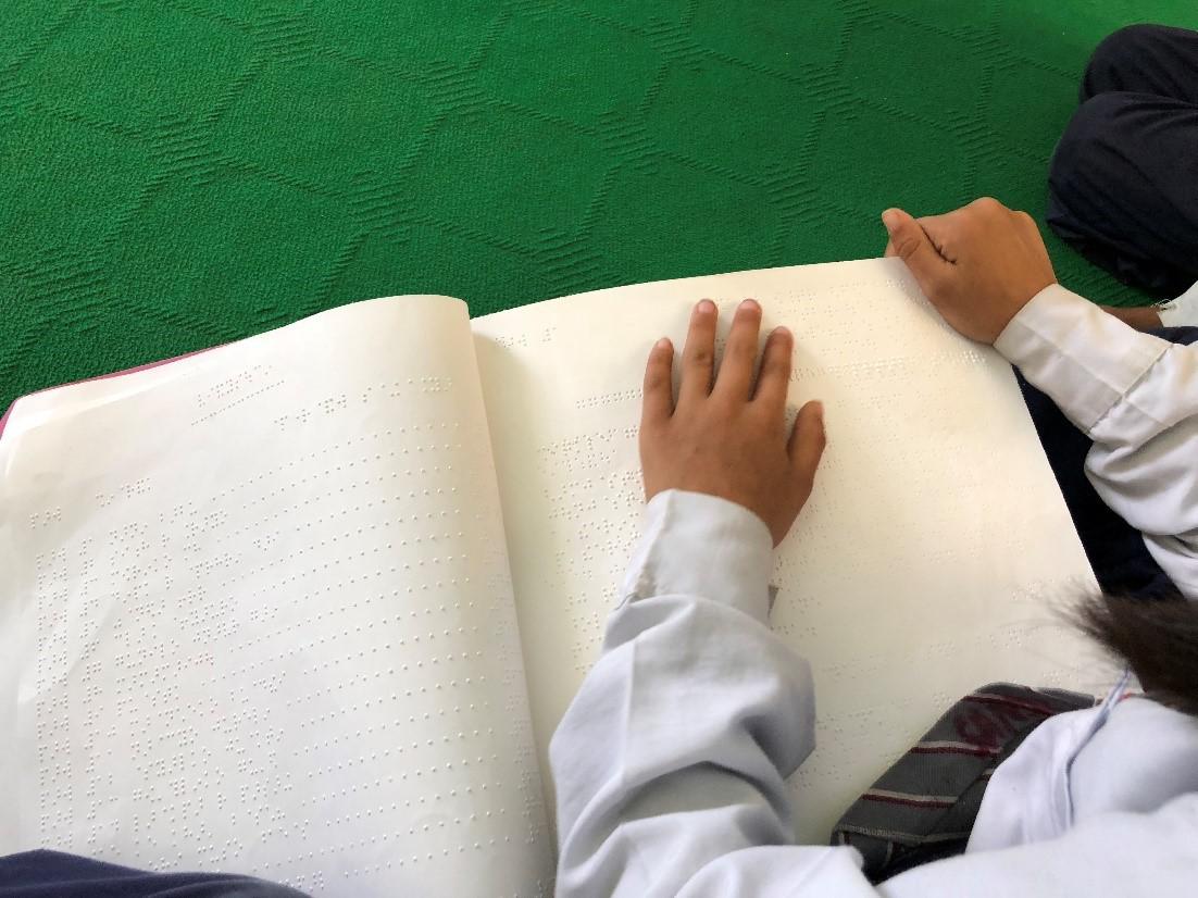 A student who is blind using a braille textbook in a mainstream classroom, public school, Kathmandu, Nepal. May 9, 2018 Human Rights Watch.