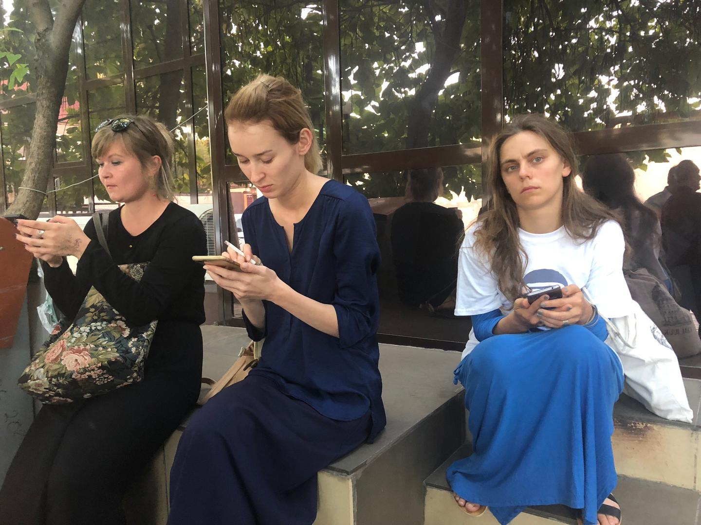 Journalists and human rights defends wait on the doorstep of a Chechnyan court building after the judge closed the hearings for human rights defender Oyub Titiev to the public.