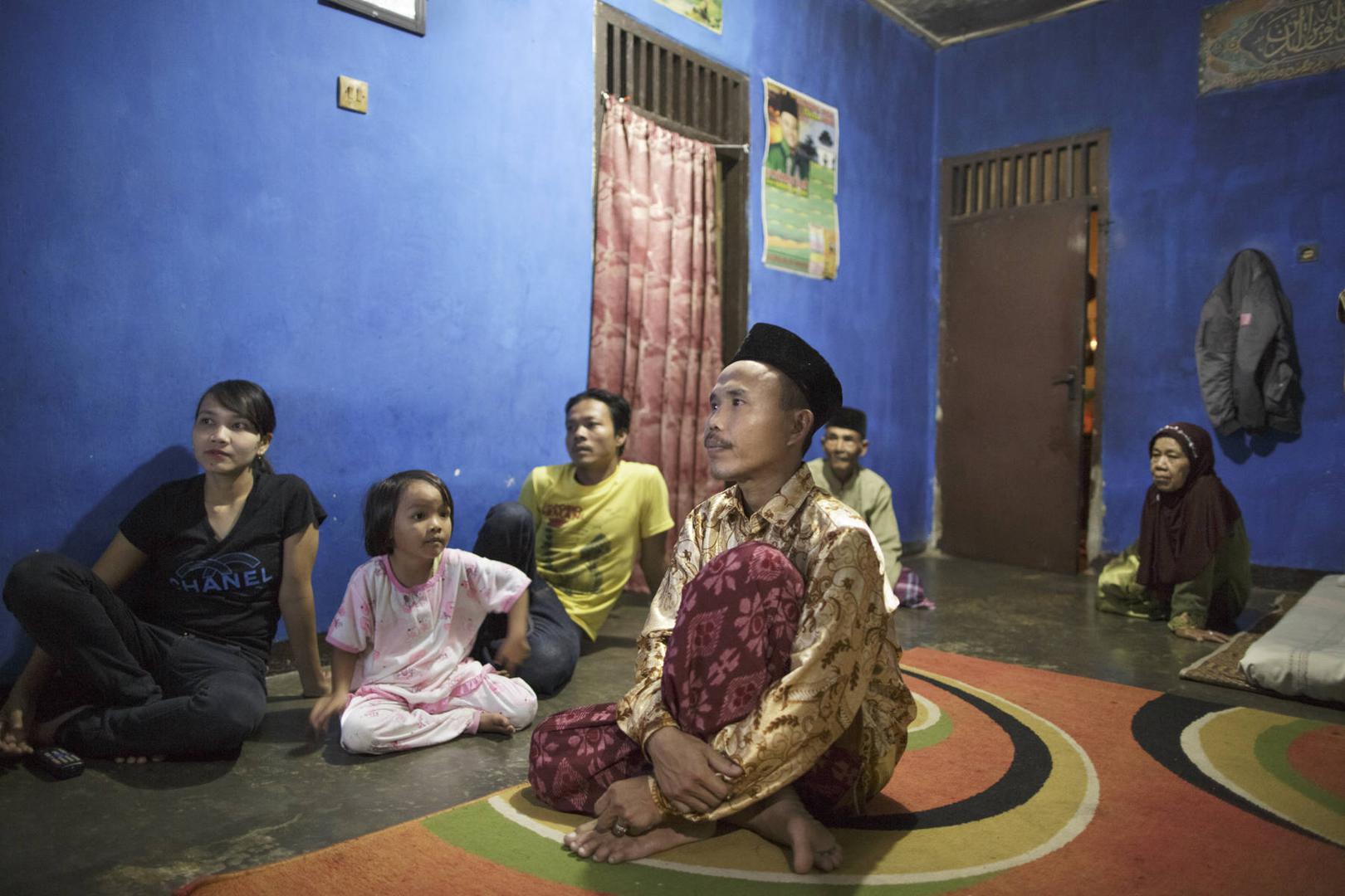 Sodikin menonton televisi bersama keluarganya di rumah mereka di Cianjur, Jawa Barat. 