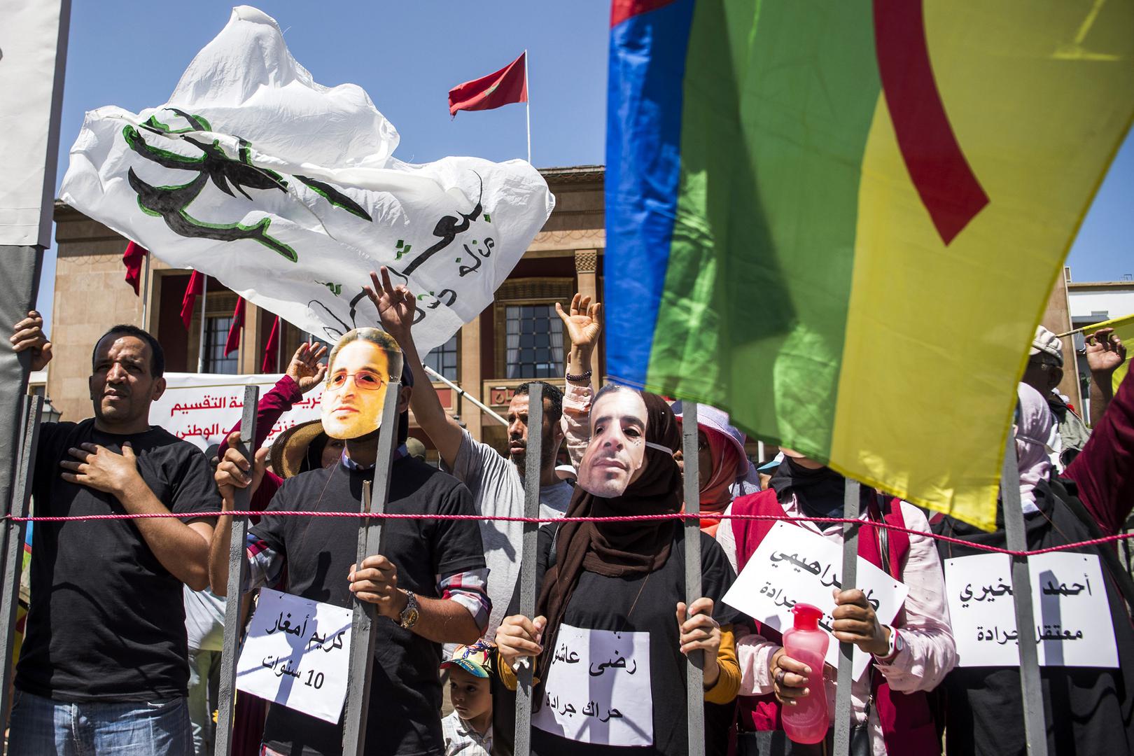 Rabat, Morocco, July 15, 2018: demonstrators protest heavy jail sentences on imprisoned activists by wearing masks showing their faces. © 2018 Fadel Senna/AFP/Getty Images