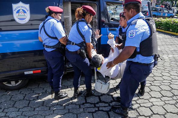 La policía antidisturbios arresta una persona durante una protesta en contra del Presidente Daniel Ortega en Managua.