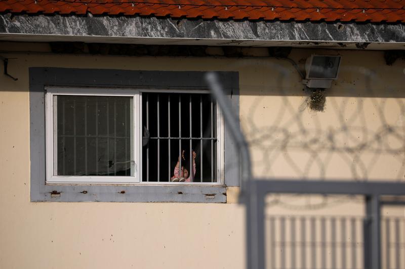 Une jeune fille migrante aperçue à travers la fenêtre d'un centre de rétention provisoire à Fylakio, en Grèce, le 30 avril 2018.