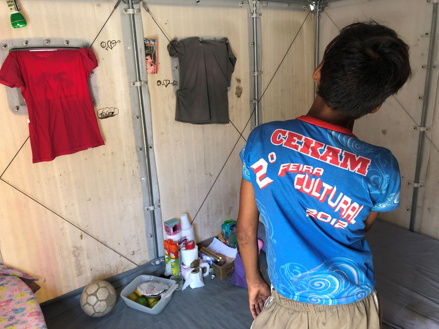 Pedro M., de 12 anos, dentro do alojamento onde mora com sua irmã Mariana, de 13 anos, em um abrigo da ONU em Roraima em outubro de 2019. 