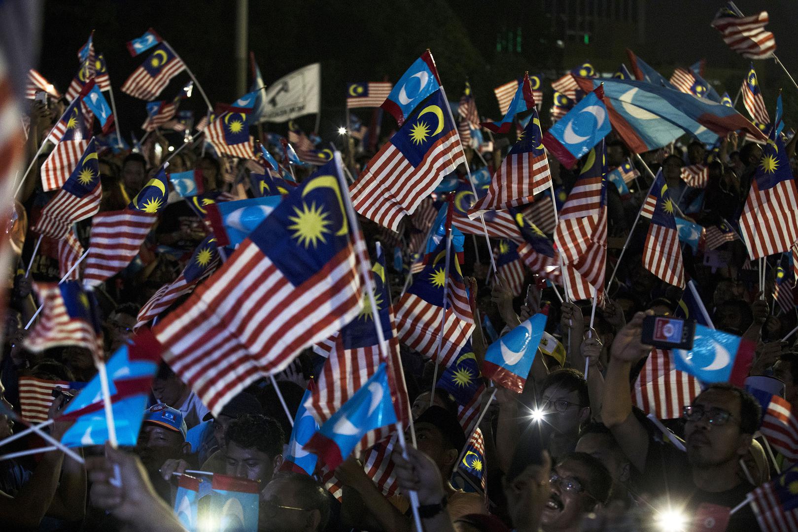 Attendees hold up smartphones and wave Malaysian national flags and People's Justice Party flags at a Pakatan Harapan alliance event in Petaling Jaya, Selangor, Malaysia, on Wednesday, May 16, 2018. 