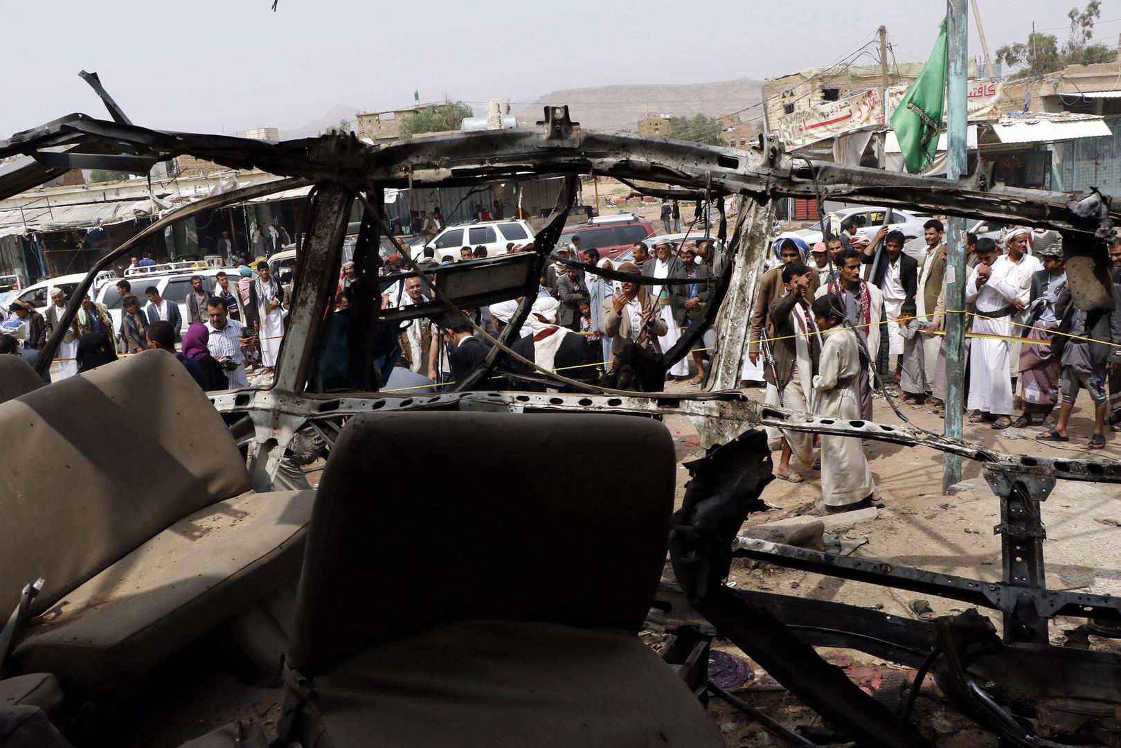 People are seen near a bus destroyed by an airstrike that killed dozens of children, in a photograph taken on August 12, 2018 in Saada, Yemen.