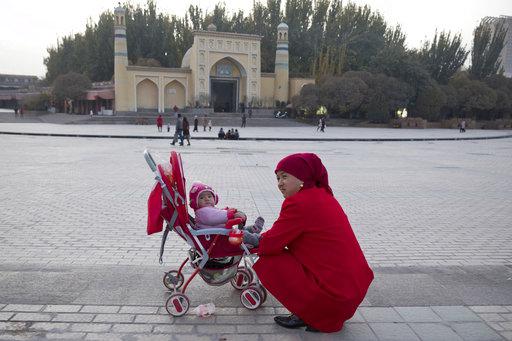 A woman tends to her child near the Id Kah Mosque in Kashgar in western China's Xinjiang region, November 4, 2017.