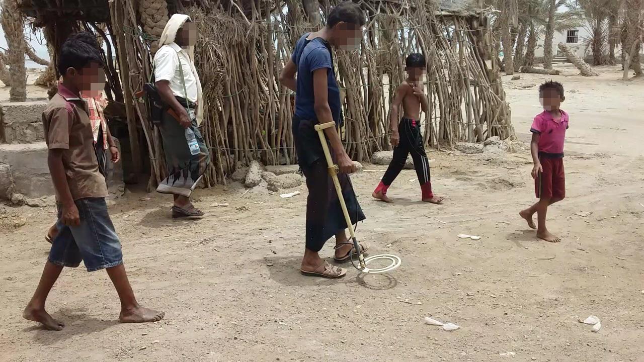 A deminer works with children following him in Zuheiri, a town on the western coast. © 2018 Private