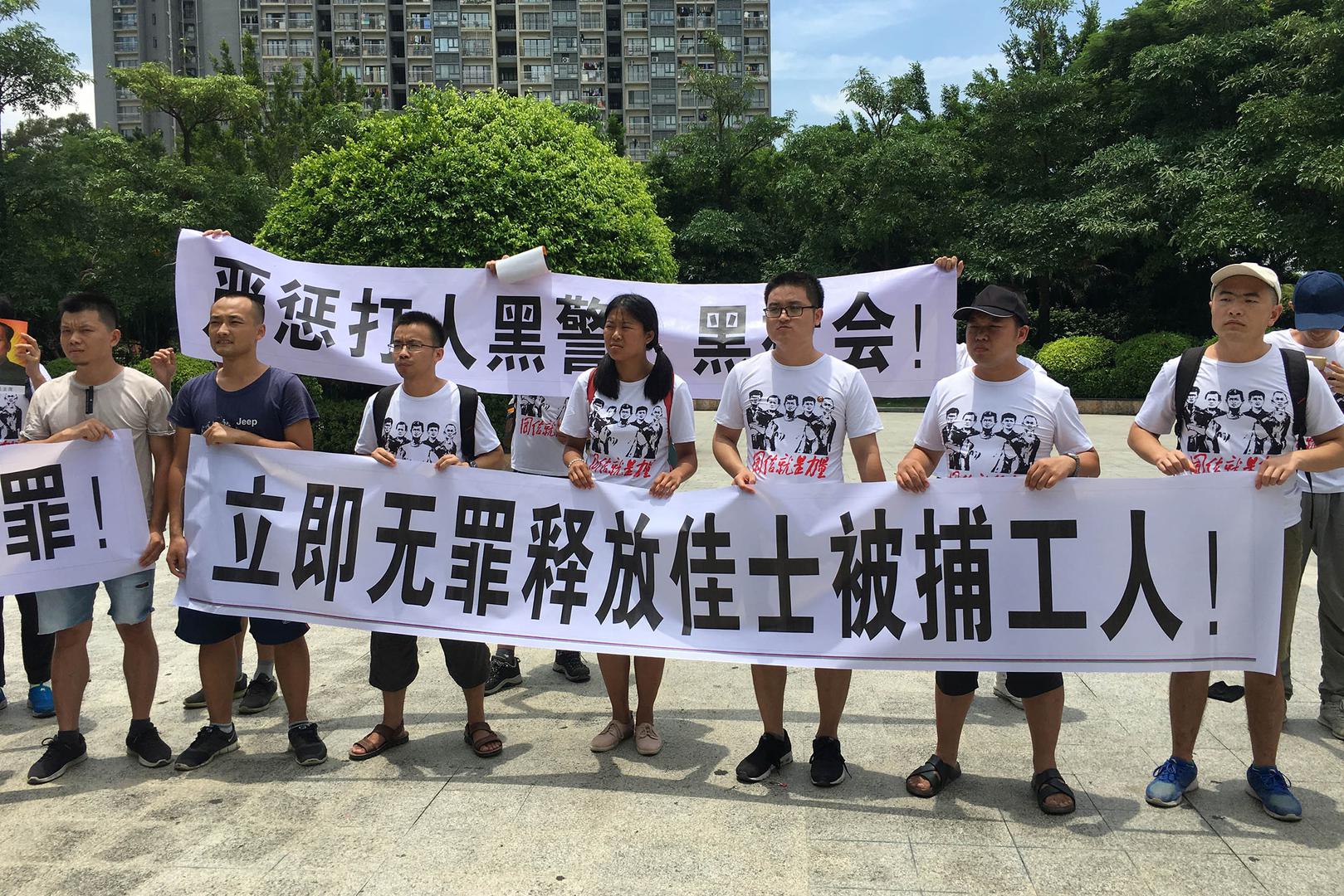 People hold banners at a demonstration in support of factory workers of Jasic Technology, outside Yanziling police station in Pingshan district, Shenzhen, Guangdong province, China August 6, 2018.