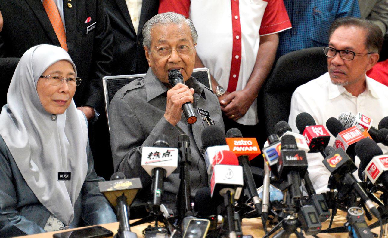 Malaysian Prime Minister Mahathir Mohamad, center, speaks next to Deputy Prime Minister Wan Azizah Wan Ismail, left, and People's Justice Party President Anwar Ibrahim, right, during a press conference in Kuala Lumpur, Malaysia, Friday, Jan. 4, 2019.